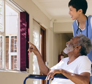 Man in wheel chair point showing a nurse something out the window